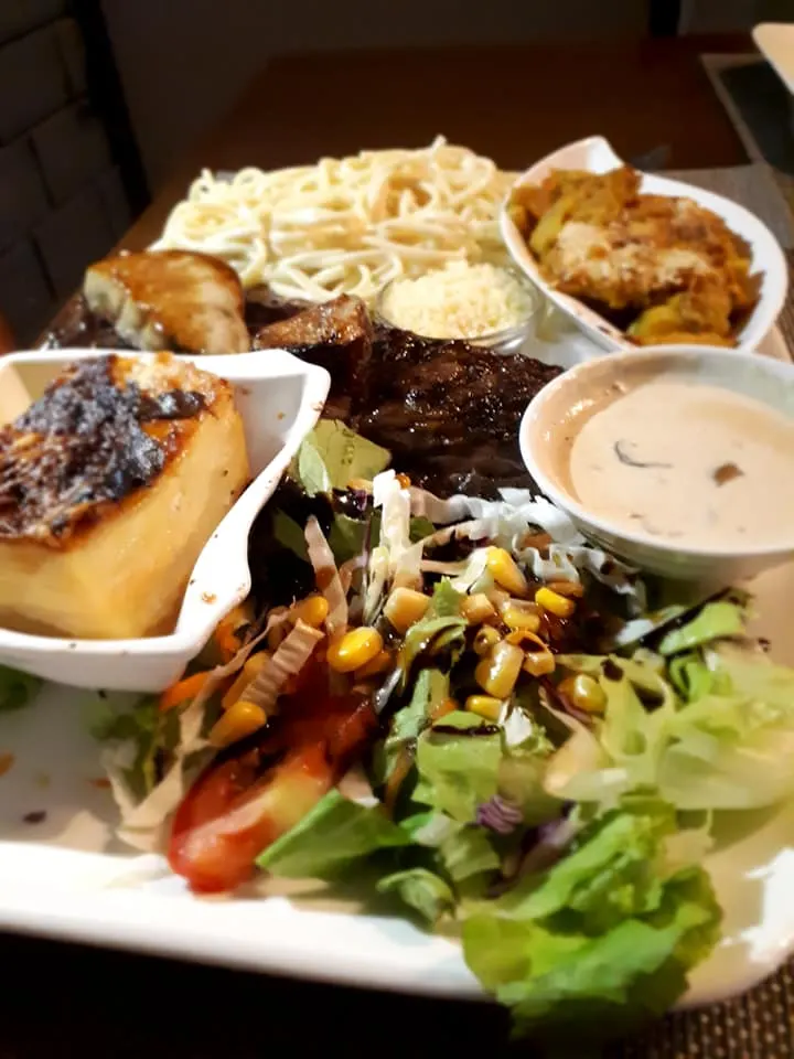 Une assiette de La Grilladine : viande grillée, gratin, salade et sauce